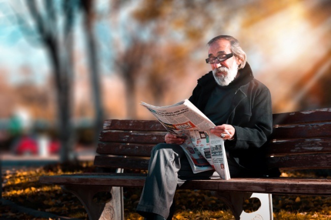 photo of an elderly man reading a newspaper with presbyopia glasses